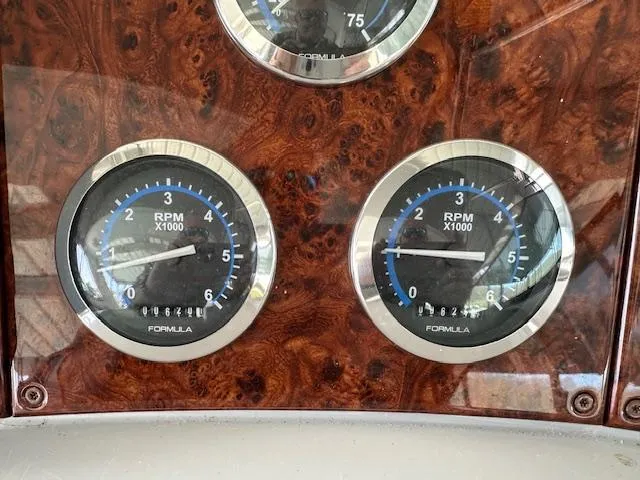Slide: The Image of Dashboard of 2004 Formula 400 Super Sport with RPM gauges on wood panel. - 12