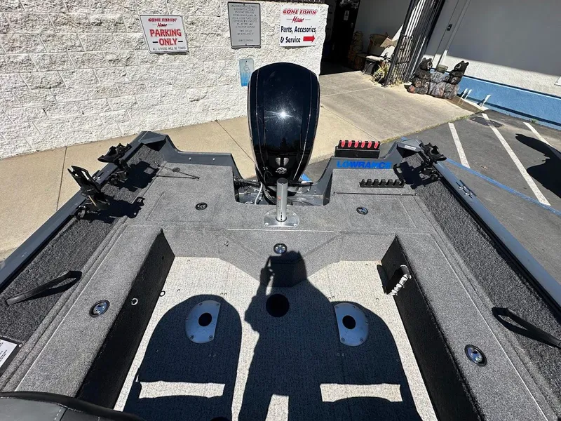 Slide: The Image of 2020 Tracker Pro Guide V-16 SC boat interior with motor and fishing rod holders. - 20