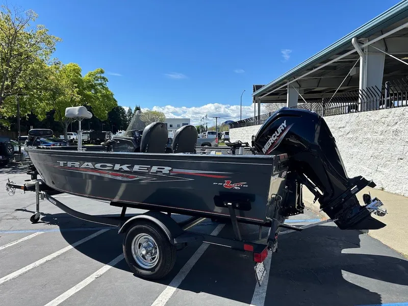 Slide: The Image of 2020 Tracker Pro Guide V-16 SC boat on trailer, parked outdoors under clear blue sky. - 6