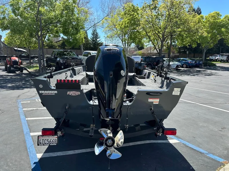 Slide: The Image of 2020 Tracker Pro Guide V-16 SC boat parked in a sunny lot with trees. - 7