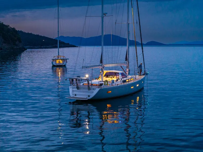The Image of Sailboats anchored at dusk on calm water, featuring a 2018 Amel 55 model. - 0
