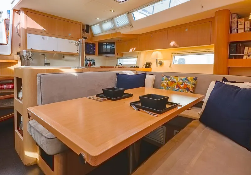 Slide: The Image of Luxurious interior of a 2018 Amel 55 yacht with modern dining area and cozy seating. - 11