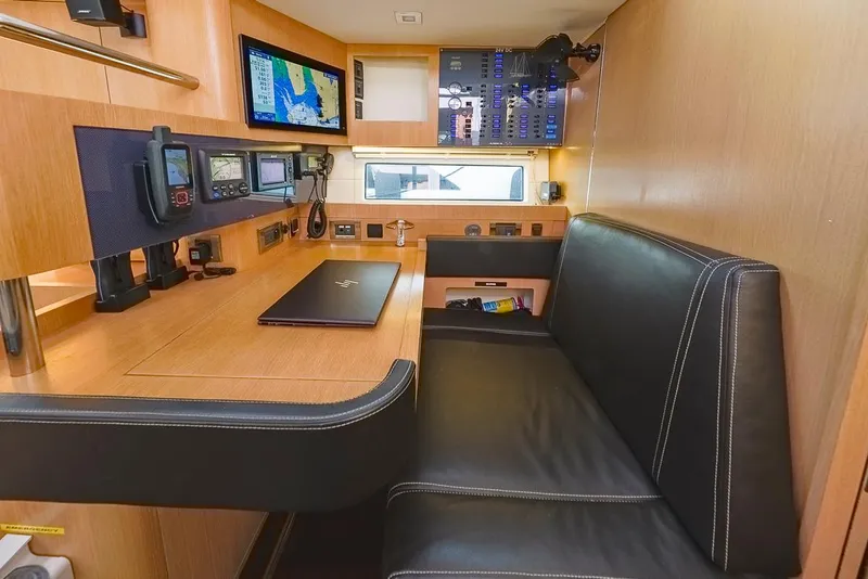 Slide: The Image of Navigation station inside 2018 Amel 55 yacht with control panels and seating. - 14