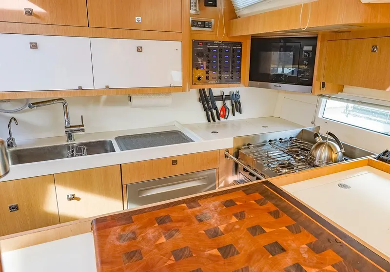 Slide: The Image of Modern kitchen in a 2018 Amel 55 yacht with wooden cabinetry and stainless steel appliances. - 17