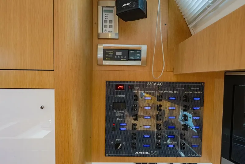 Slide: The Image of Control panel of a 2018 Amel 55 yacht, featuring 230V AC switches and displays. - 27