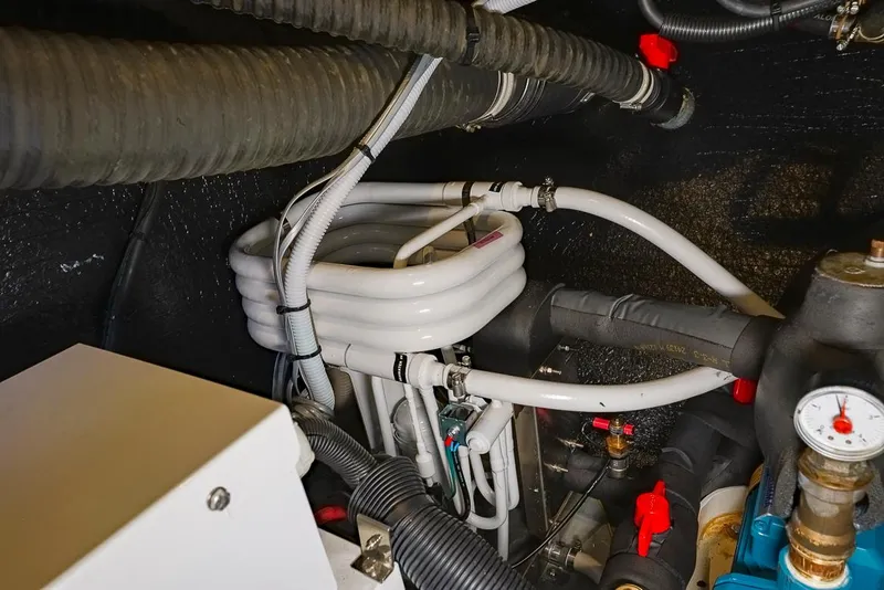Slide: The Image of Engine room of 2018 Amel 55 yacht with coiled hoses and mechanical components. - 31