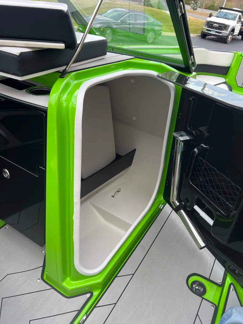 Slide: The Image of 2022 Yamaha Boats 255XD, green interior storage compartment, open door, modern design. - 8