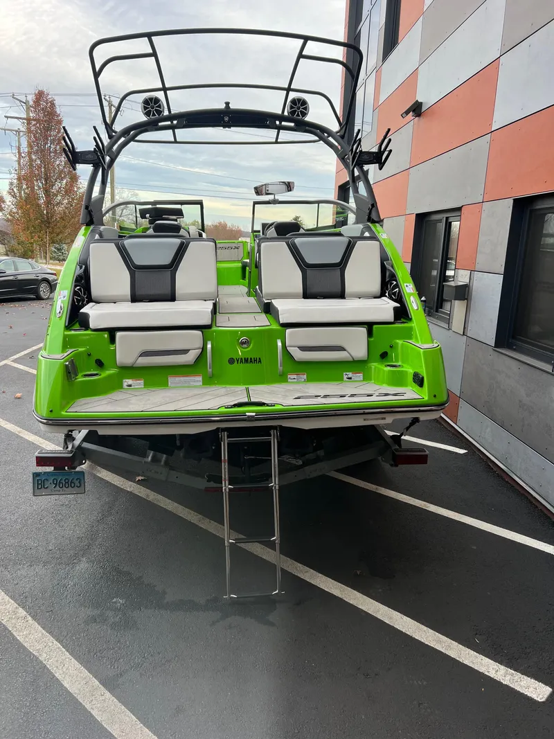 Slide: The Image of 2022 Yamaha Boats 255XD in vibrant green, docked with rear seating and ladder visible. - 9