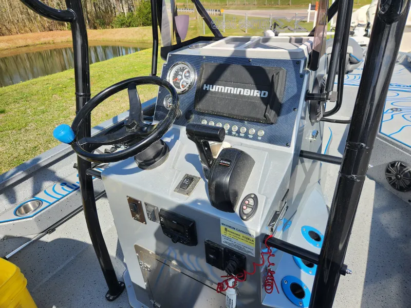 Slide: The Image of 2022 Xpress H22B boat console with steering wheel and Humminbird electronics. - 12