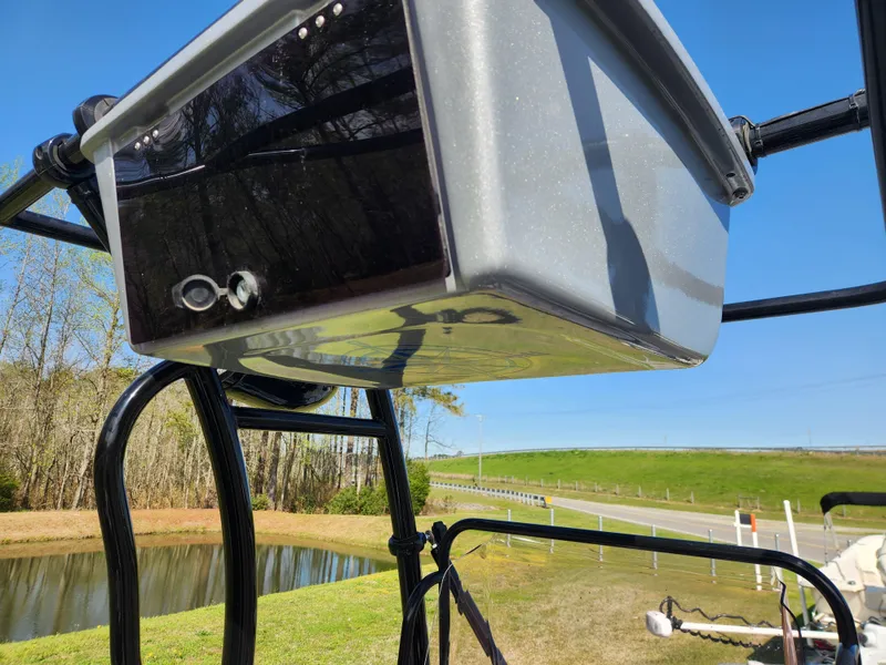 Slide: The Image of 2022 Xpress H22B boat console, outdoor setting, clear blue sky, and grassy landscape. - 13