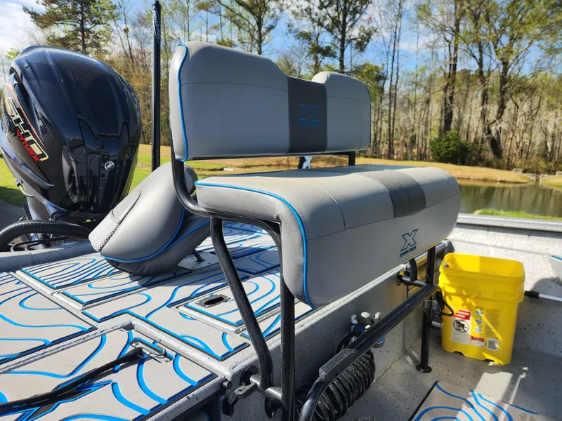 Slide: The Image of 2022 Xpress H22B boat interior with gray seating, blue accents, and a yellow bucket. - 14