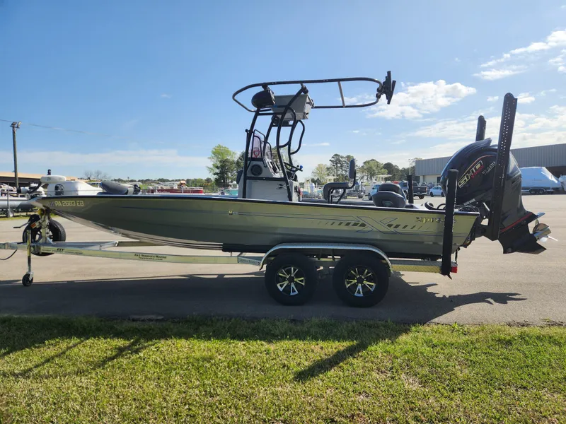 Slide: The Image of 2022 Xpress H22B boat on trailer, parked outdoors under clear blue sky. - 5