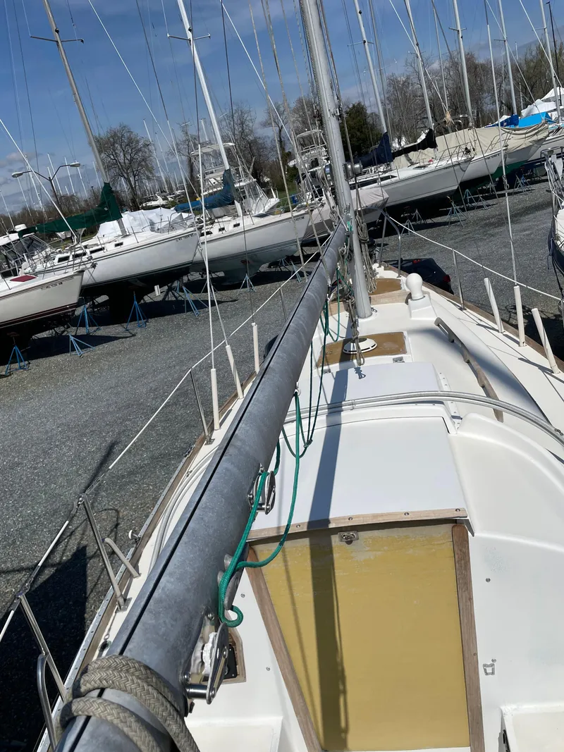 Slide: The Image of 1979 Bristol 32 sailboat on land, showcasing deck and mast in a boatyard. - 10