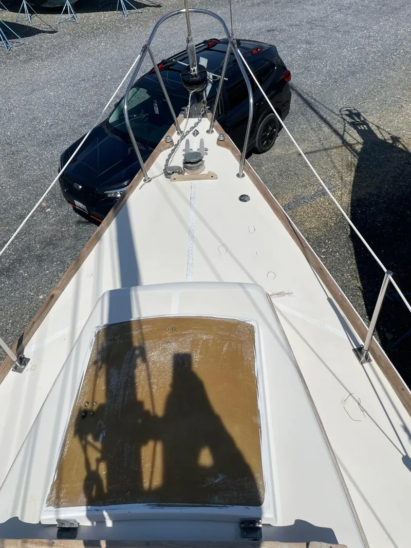 Slide: The Image of 1979 Bristol 32 sailboat deck with car in background, shadow on deck. - 11