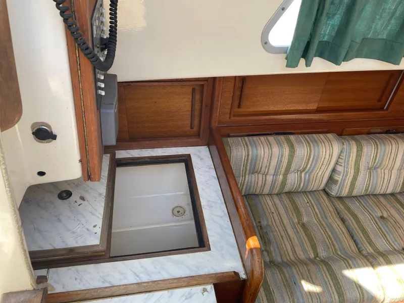 Slide: The Image of Interior of a 1979 Bristol 32 sailboat with wood paneling and striped upholstery. - 16