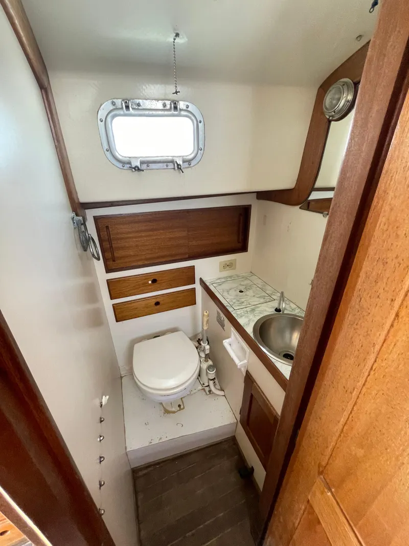 Slide: The Image of 1979 Bristol 32 yacht bathroom with sink, toilet, and wooden cabinetry. - 22