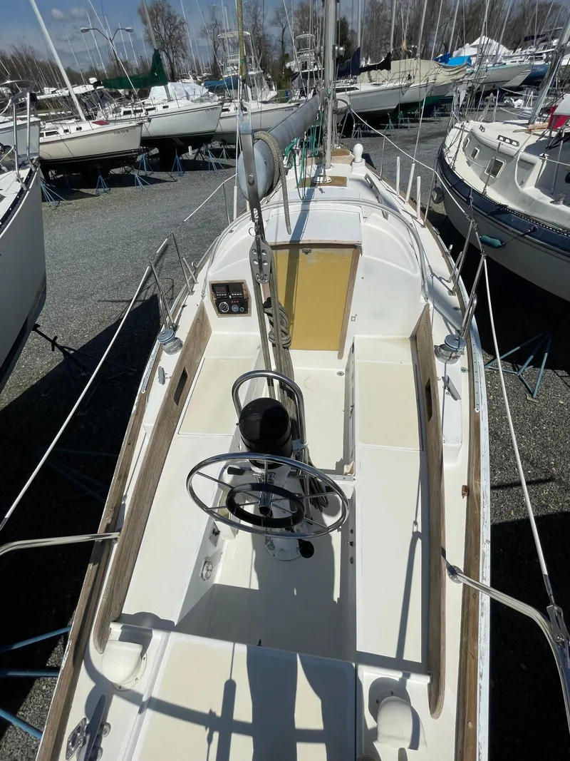 Slide: The Image of 1979 Bristol 32 sailboat with dual steering wheels, docked among other boats. - 5