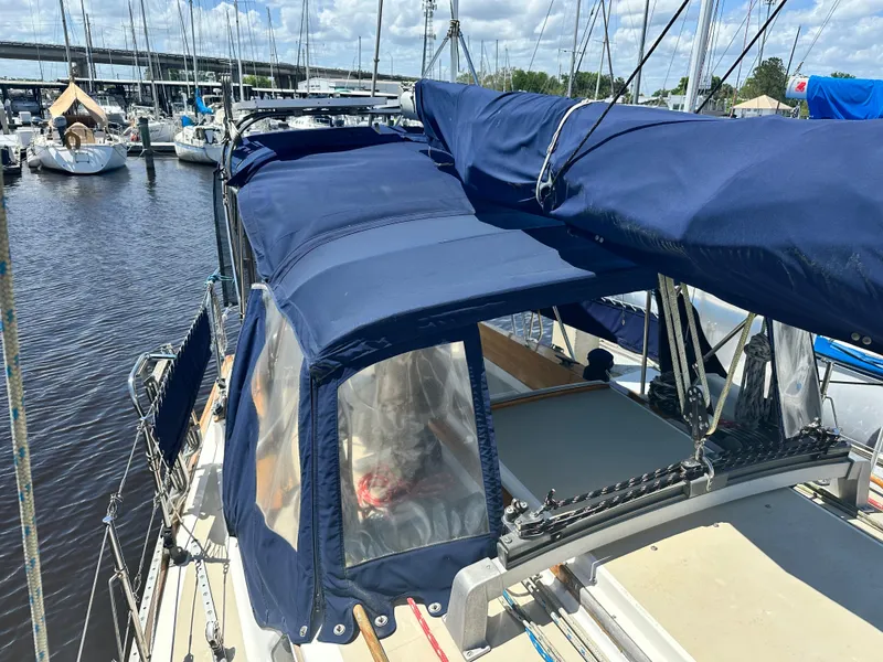 Slide: The Image of 1988 Cape Dory 30 MK II sailboat with blue canvas cover docked at marina. - 17