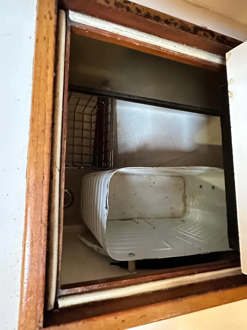 Slide: The Image of Storage compartment inside 1988 Cape Dory 30 MK II boat, featuring a white container. - 28
