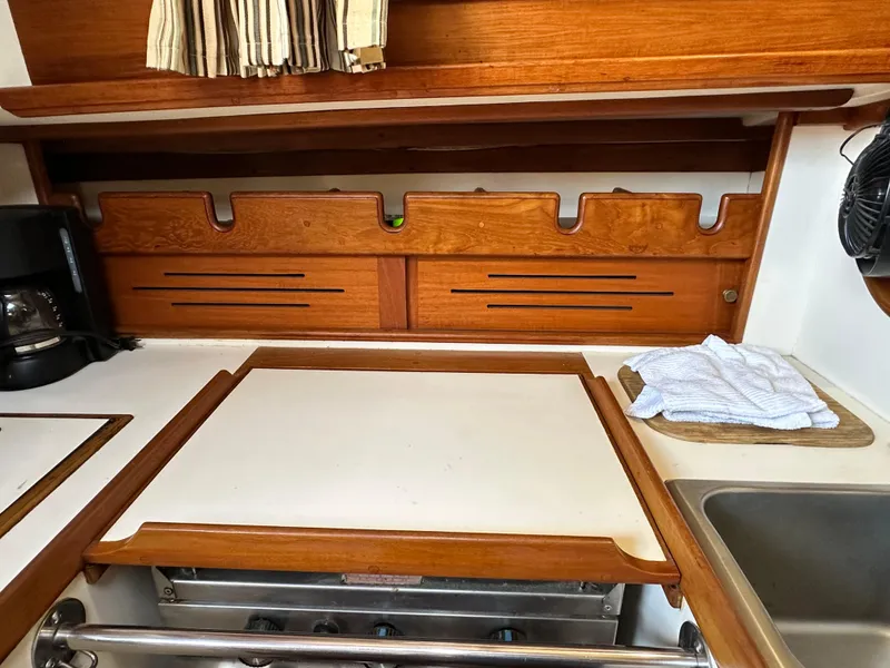 Slide: The Image of 1988 Cape Dory 30 MK II galley with wooden cabinetry and countertop. - 29