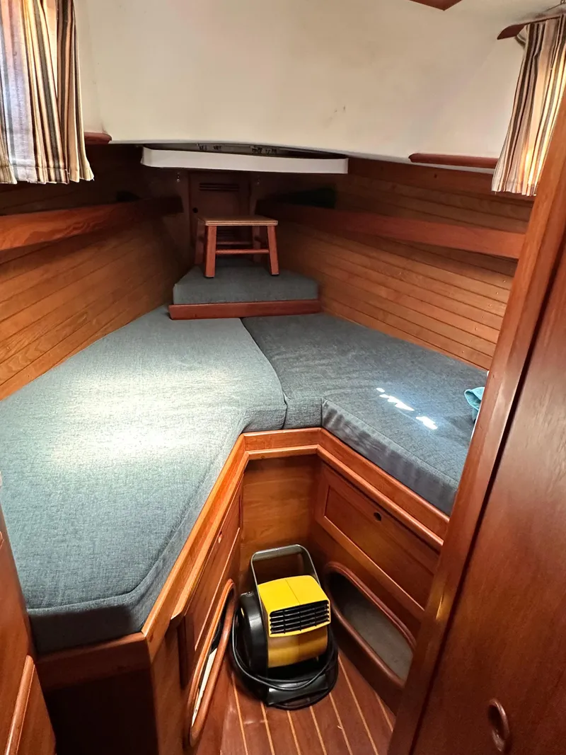 Slide: The Image of 1988 Cape Dory 30 MK II cabin interior with wooden finish and cozy bedding. - 32