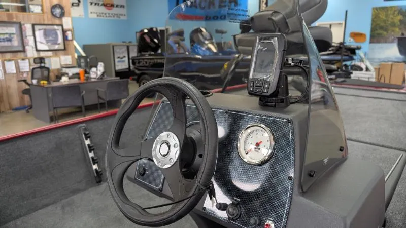 Slide: The Image of 2025 Bass Tracker Classic XL boat dashboard with steering wheel and navigation system. - 3