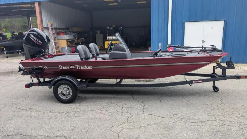 Slide: The Image of 2025 Bass Tracker Classic XL boat on trailer outside blue building. - 8