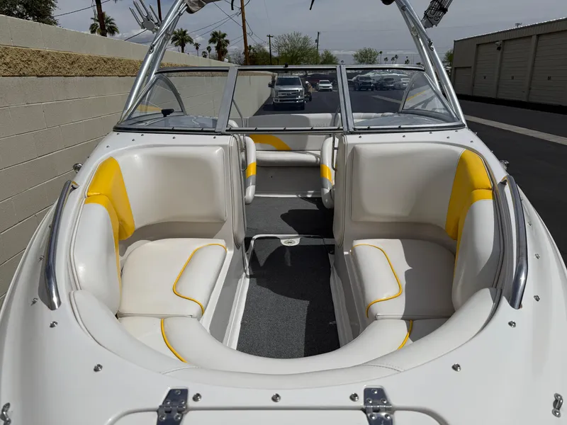 Slide: The Image of 2008 Reinell Bowrider 220LSE with white and yellow interior, parked outdoors. - 10