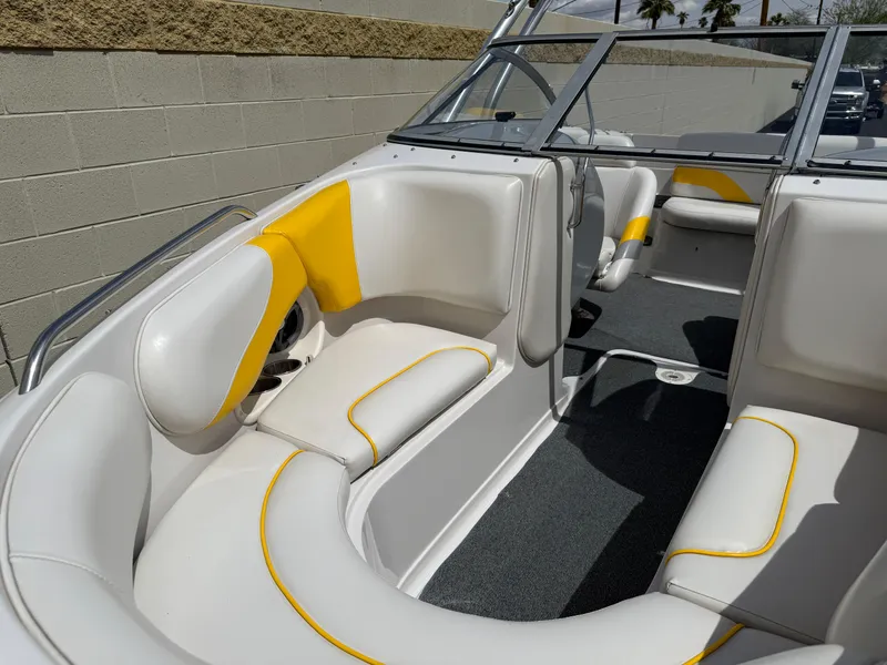 Slide: The Image of 2008 Reinell Bowrider 220LSE interior with white and yellow seating, gray carpet, and windshield. - 11