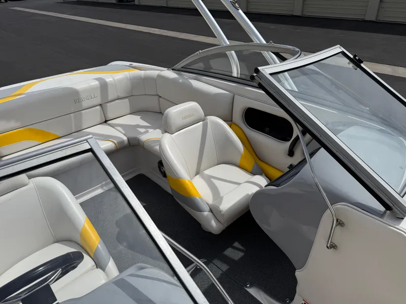 Slide: The Image of 2008 Reinell Bowrider 220LSE interior with white and yellow seating, open windshield. - 14