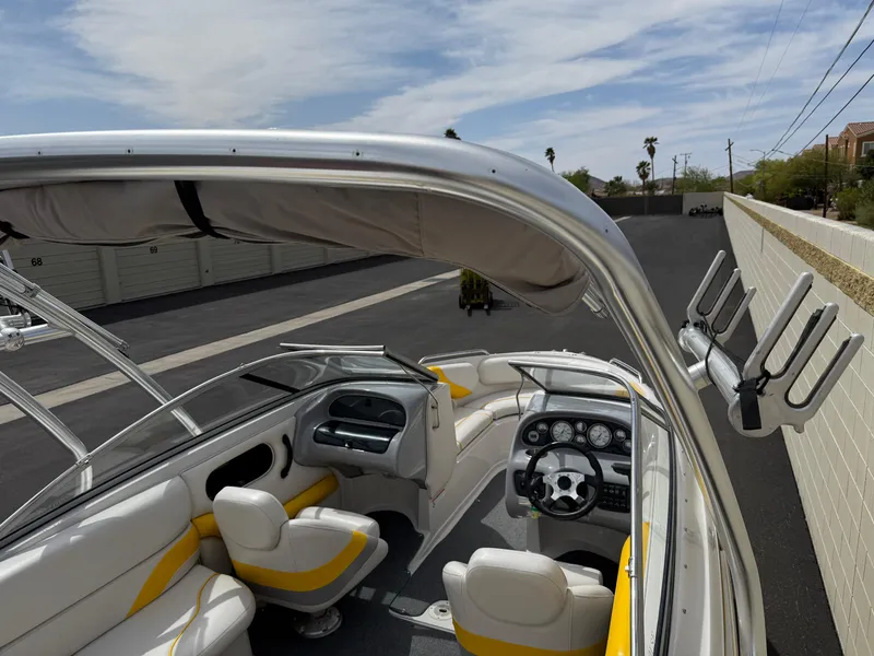 Slide: The Image of 2008 Reinell Bowrider 220LSE interior with white and yellow seating, parked outdoors. - 25