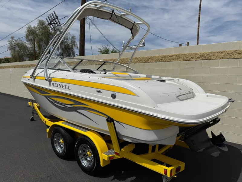 Slide: The Image of 2008 Reinell Bowrider 220LSE boat on trailer, yellow and white design, parked outdoors. - 5
