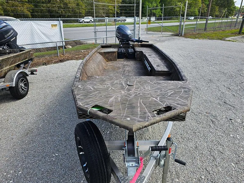 Slide: The Image of 2025 G3 Gator Tough 16 DK boat on trailer, camo design, parked outdoors. - 4