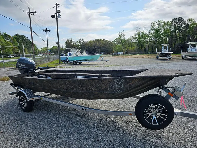 Slide: The Image of 2025 G3 Gator Tough 16 DK boat on trailer, camo design, parked outdoors. - 6