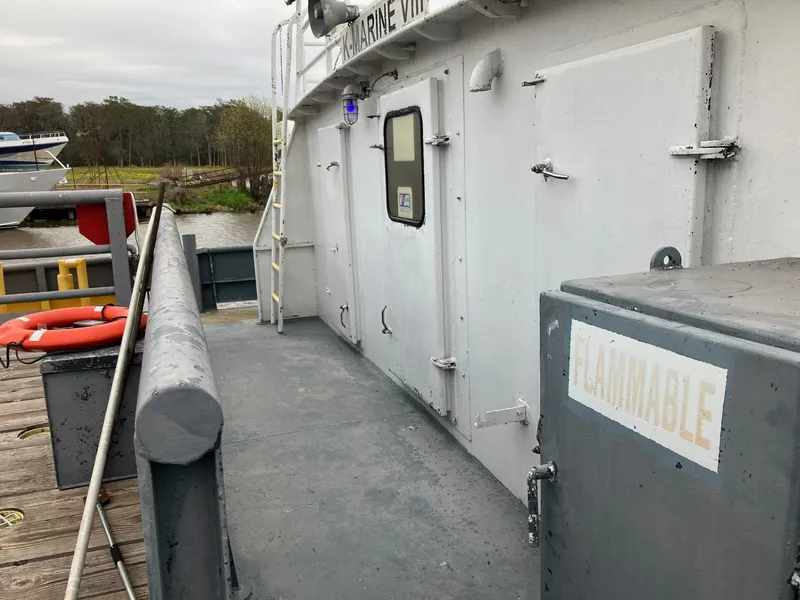 Slide: The Image of 1994 commercial offshore crew boat docked, showing side view with safety equipment. - 6