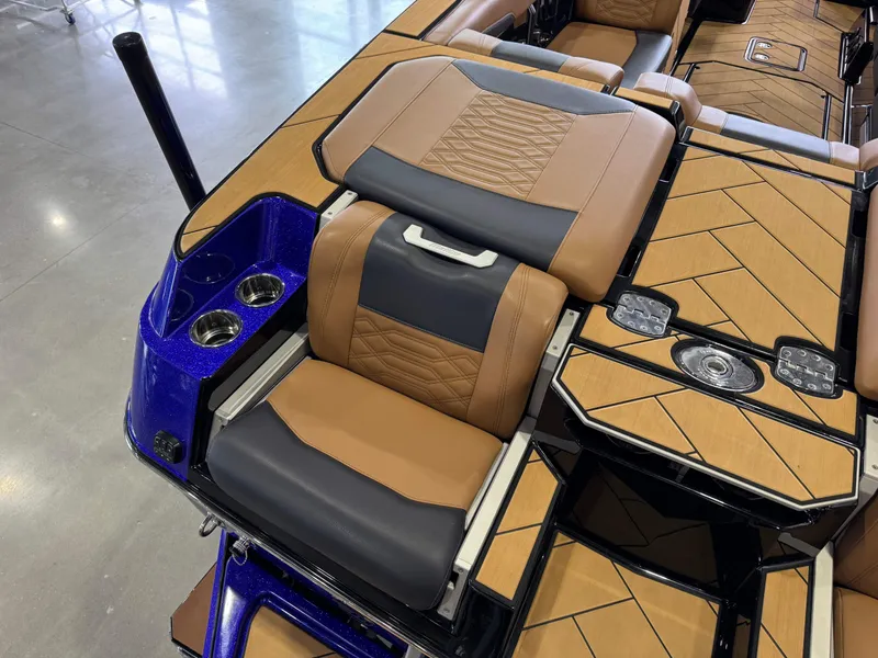 Slide: The Image of 2023 Malibu Wakesetter 26 LSV interior with tan and gray seating, cup holders, and stylish flooring. - 12