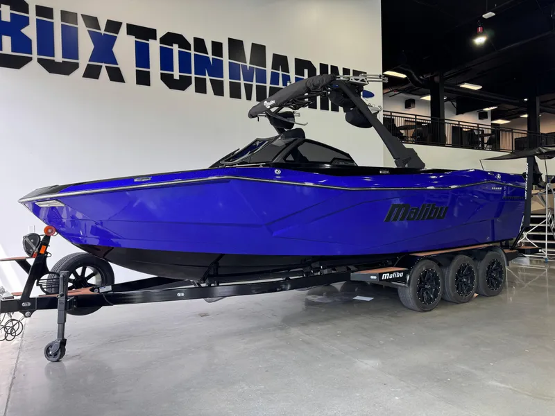 Slide: The Image of 2023 Malibu Wakesetter 26 LSV boat in showroom, vibrant blue color, on trailer. - 3