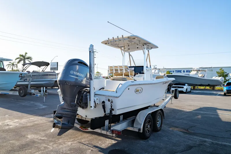 Slide: The Image of 2018 Sea Hunt Triton 210 boat on trailer with Yamaha outboard motor, parked outdoors. - 10