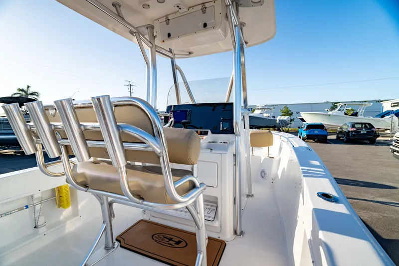 Slide: The Image of 2018 Sea Hunt Triton 210 boat interior with helm and seating, parked outdoors. - 13