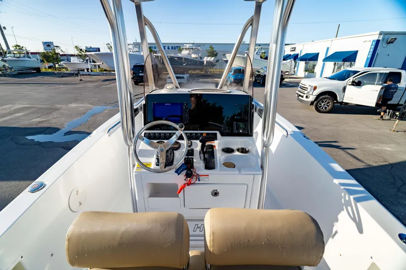 Slide: The Image of 2018 Sea Hunt Triton 210 boat interior with steering console and seating in a marina setting. - 14