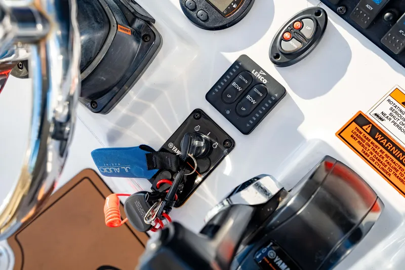 Slide: The Image of Control panel of a 2018 Sea Hunt Triton 210 boat with keys and warning labels. - 19