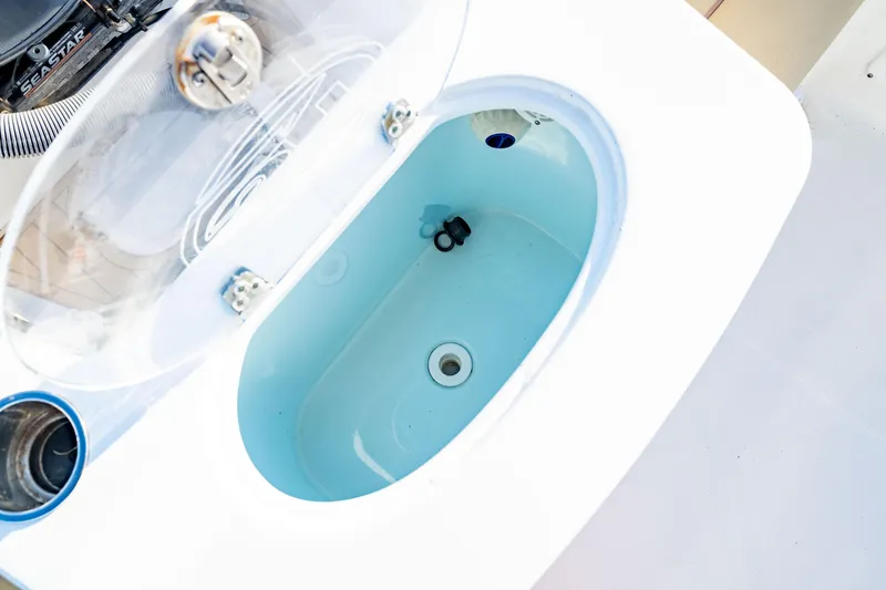 Slide: The Image of Livewell on 2018 Sea Hunt Triton 210 boat, featuring a clear lid and blue interior. - 21