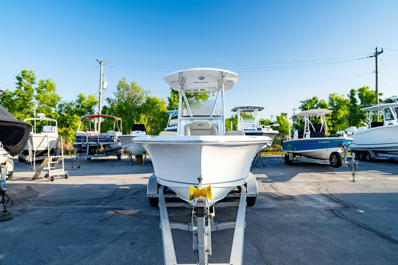 Slide: The Image of 2018 Sea Hunt Triton 210 boat on trailer, parked outdoors under clear blue sky. - 3