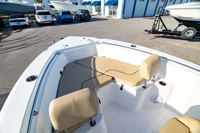 Slide: The Image of 2018 Sea Hunt Triton 210 boat with beige seating, parked in a marina lot. - 4