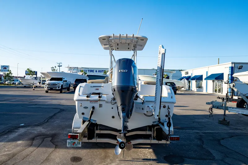 Slide: The Image of 2018 Sea Hunt Triton 210 boat with outboard motor in a marina parking lot. - 8
