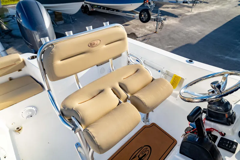 Slide: The Image of 2018 Sea Hunt Triton 210 boat interior with beige seating and steering wheel. - 9