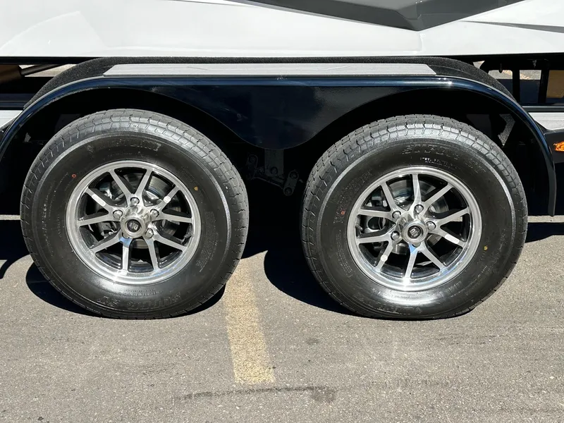 Slide: The Image of 2024 ATX Surf Boats 20 Type-S trailer wheels on pavement, showcasing sleek design and durability. - 34