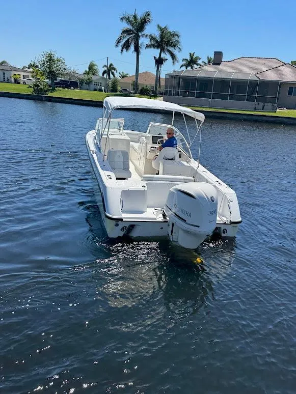 Slide: The Image of Edgewater 245 CX boat from 2009 cruising on a sunny canal with palm trees. - 16