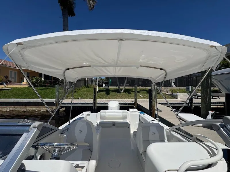 Slide: The Image of 2009 Edgewater 245 CX boat with canopy, docked under clear blue sky. - 17