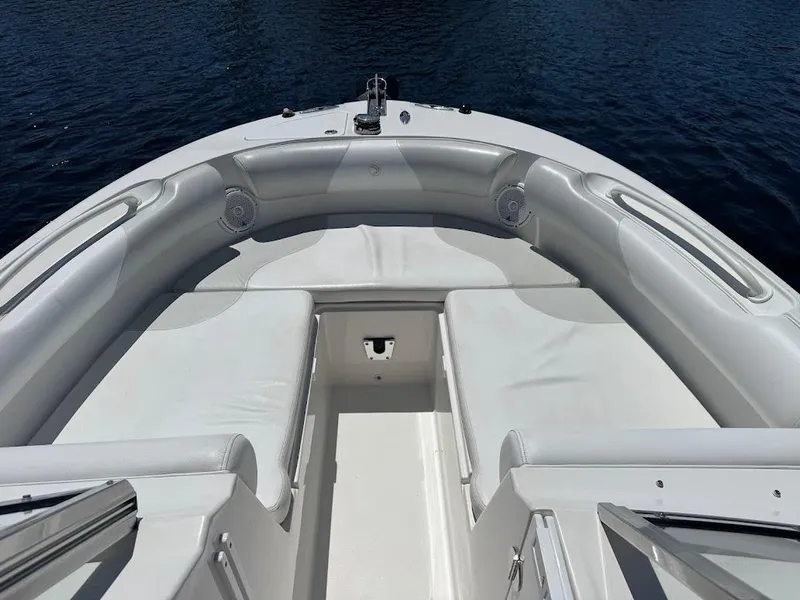 Slide: The Image of Bow seating area of 2009 Edgewater 245 CX boat with white cushions and speakers. - 19